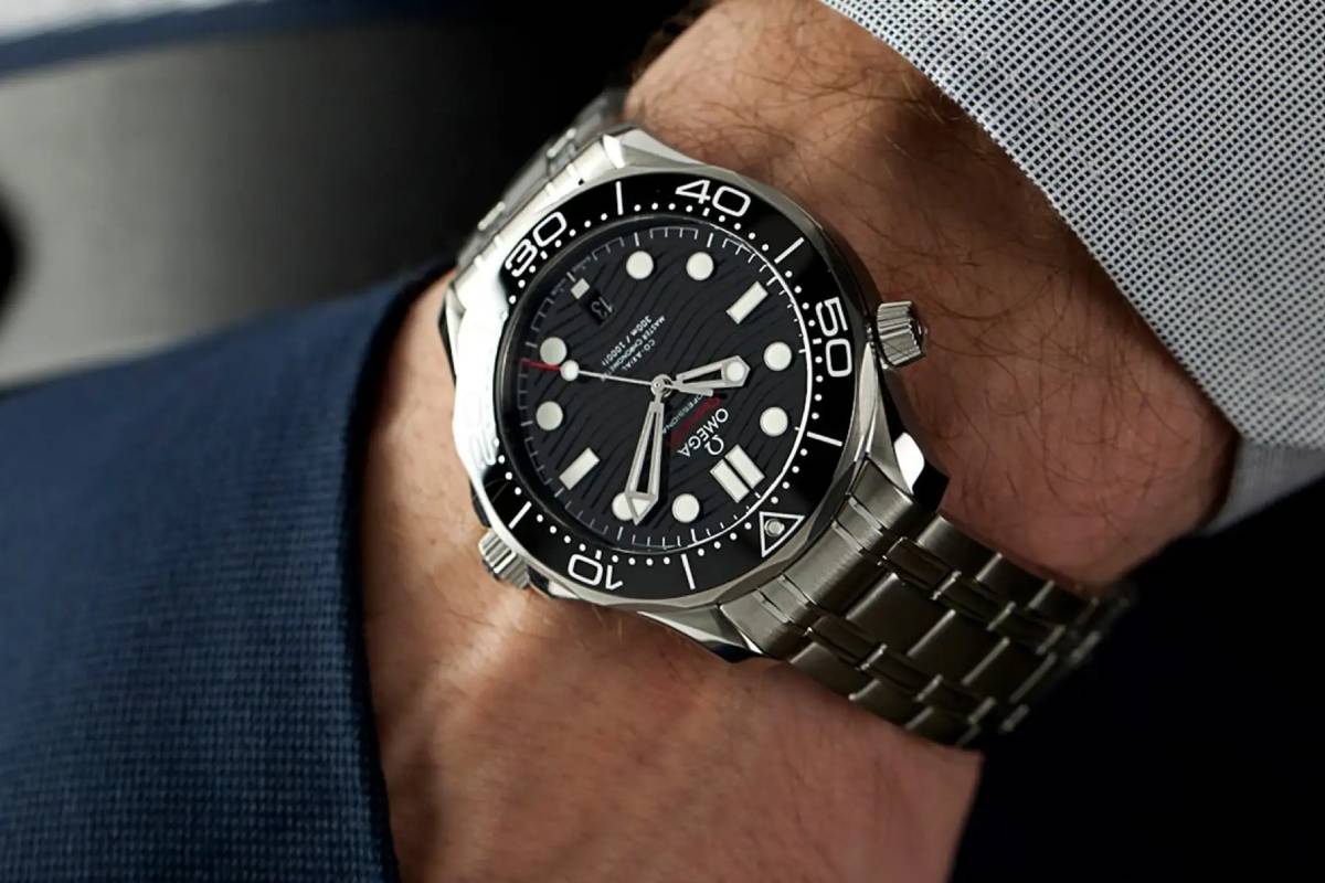 Uomo che indossa un Omega Seamaster Diver 300M con quadrante nero e bracciale in acciaio inossidabile, ideale per l'uso quotidiano e le occasioni eleganti.