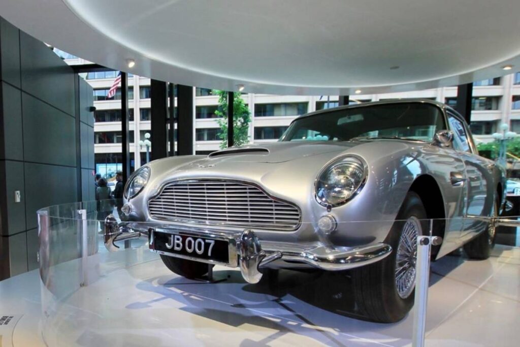 Aston Martin DB5, l'iconica auto di James Bond esposta in un museo, simbolo di eleganza e lusso automobilistico.