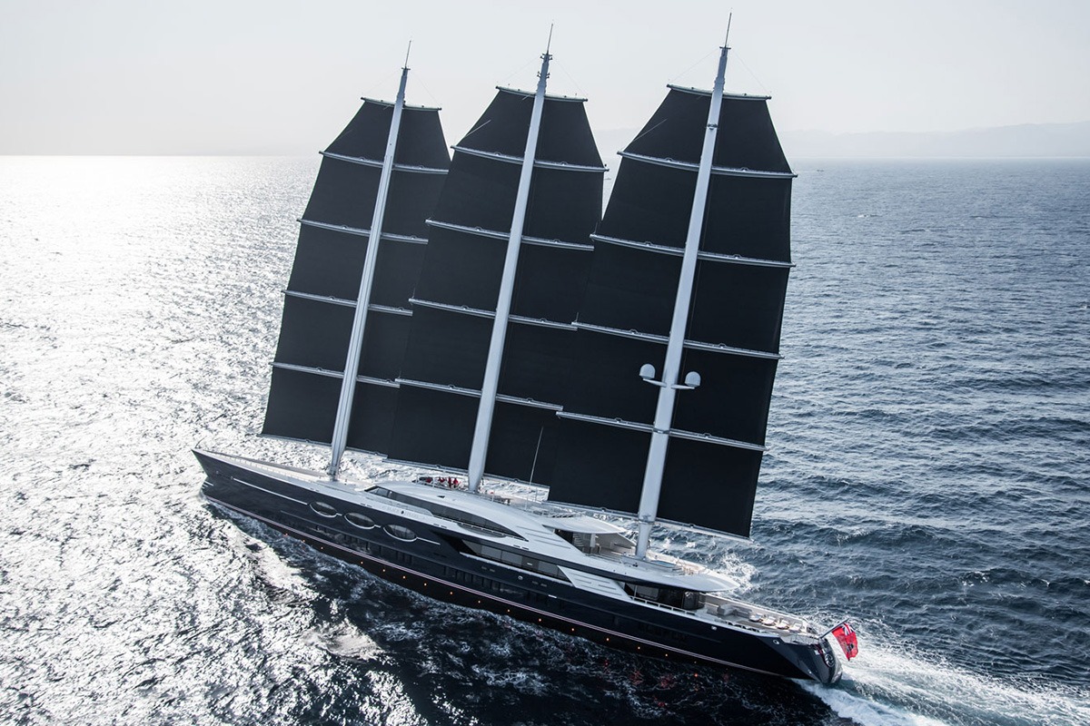 Il Black Pearl di Oceanco, un innovativo mega yacht a vela, naviga sull'oceano con le sue maestose vele nere spiegate, rappresentando lusso e sostenibilità.